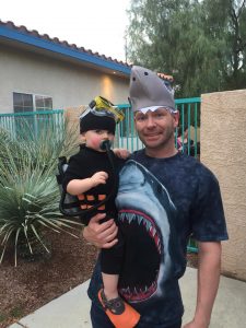 Baby boy dressed as a scuba diver with dad as a shark