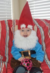 Baby smiling in a gnome Halloween costume