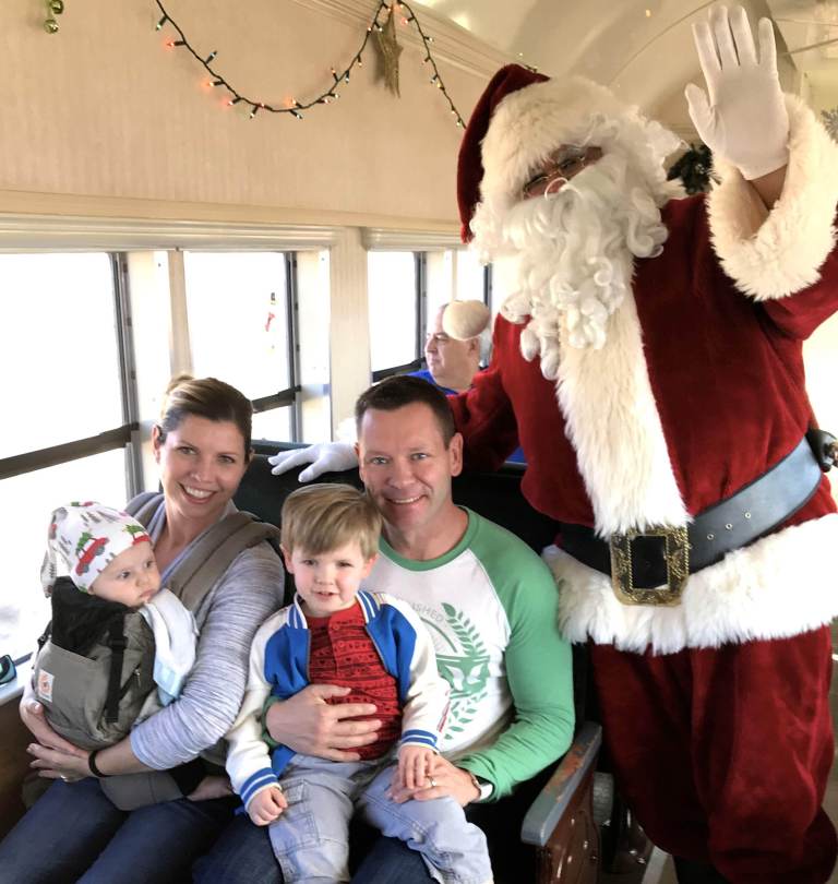 Family with two small boys and Santa on the Santa train in Boulder City