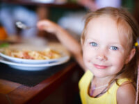 kids eat free girl eating at a restaurant