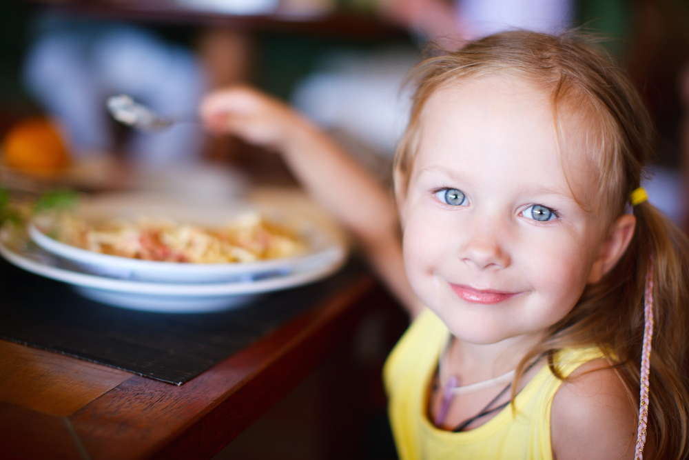 kids eat free girl eating at a restaurant